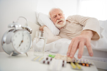 Wall Mural - Photo of elderly man pensioner lie bad rest home indoors unwell unhealthy look meds pills painkiller