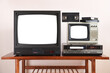© lial88 - Two antiquated vintage TVs with VCRs with isolated white screens stand on a vintage table in a 1990s tenement building.