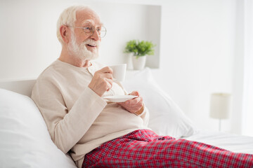 Sticker - Photo of pretty charming mature man nightwear glasses lying bed drinking morning coffee indoors inside room home