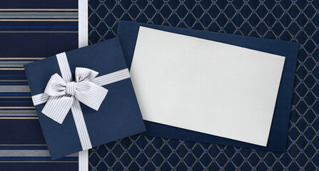 Wall Mural - Gift card and gift box with ribbon and bow isolated on elegant blue fabrics background, top view and copy space template, useful for father's day greeting