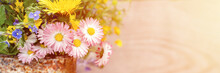 A Bouquet Of Wildflowers Of Forget-me-nots, Daisies And Yellow Dandelions In Full Bloom In A Rusty Rustic Jar Against A Background Of Wooden Planks. Cottagecore Scene. Space For Text. Banner. Flare