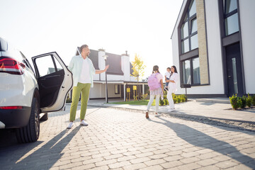 Poster - Full size photo of happy smiling family daughter come back from school mom and little son met her outside outdoors