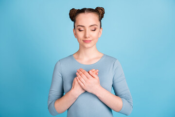 Poster - Photo o calm pretty girl hold hands heard chest enjoy closed eyes isolated on pastel blue color background