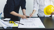 © Puwasit Inyavileart - Meeting of engineers and architects in building planning, Consulting and brainstorming experts in architectural planning using blueprints, tape measure, rulers, laptop in designing buildings.