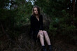 © Марина Шемедюк - young brunette woman with short hair in a black dress near the pines