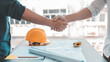 © Puwasit Inyavileart - Men shake hands after the deal is done, Architects and engineers join hands to congratulate them after the building site meeting is completed, Symbol of friendship in business of both parties.