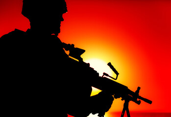 Silhouette of army infantry soldier, commando in combat helmet, armed light machine gun, standing on background of ocean horizon and sunset. Marine Corps rifleman, special forces shooter on sea shore