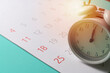 © tatomm - close up of calendar and alarm clock on the green table background, planning for business meeting or travel planning concept