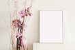 empty vertical picture frame with beautiful pink flowers on white wall background