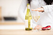 Woman holding hand above the glass of white wine to express she had enough