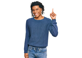 Wall Mural - Young african american man wearing casual winter sweater pointing finger up with successful idea. exited and happy. number one.