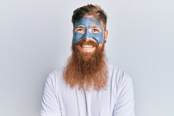 Wall Mural - Young irish redhead man wearing facial mask happy face smiling with crossed arms looking at the camera. positive person.