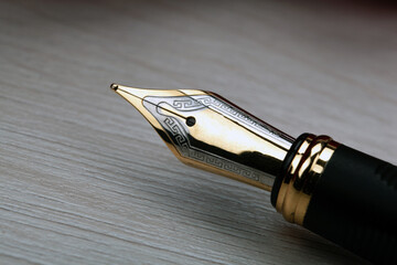 Wall Mural - gold plated fountain pen closeup on a wooden table