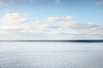 Wall Mural - Frozen Baltic sea shore on a clear day, snow texture close-up. Blue sky. Picturesque winter scenery. Seasons, nature, ecology, environment, climate change, global warming. Panoramic view, copy space