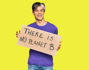 Sticker - Young hispanic man holding there is no planet b banner looking positive and happy standing and smiling with a confident smile showing teeth