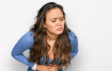 Young hispanic girl wearing casual clothes with hand on stomach because indigestion, painful illness feeling unwell. ache concept.