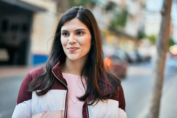 Young hispanic girl smiling happy standing at the city.