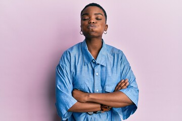 Sticker - Young african american woman with arms crossed gesture puffing cheeks with funny face. mouth inflated with air, catching air.