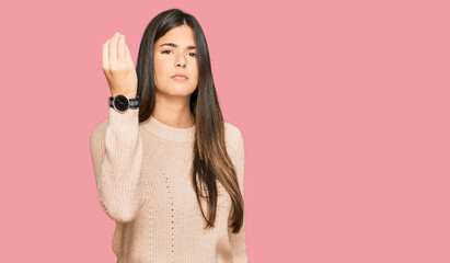 Poster - Young brunette woman wearing casual winter sweater doing italian gesture with hand and fingers confident expression