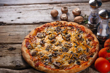 Wall Mural - Pizza ready with mushrooms and tomatoes and spices on a wooden background
