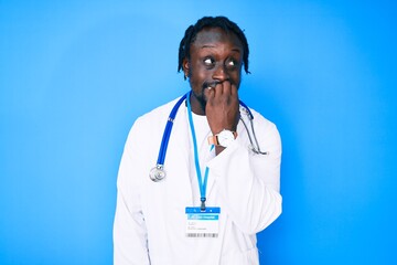 Poster - Young african american man with braids wearing doctor stethoscope and id pass looking stressed and nervous with hands on mouth biting nails. anxiety problem.