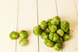 Bunch of fresh raw Brussel sprouts on a white wood table