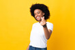 Young African American woman isolated on yellow background making money gesture