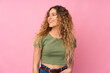 © luismolinero - Young blonde woman with curly hair isolated on pink background looking side