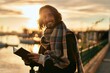 © Krakenimages.com - Young hispanic man smiling happy reading book at the port.