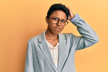 Wall Mural - Young african american girl wearing business jacket and glasses confuse and wonder about question. uncertain with doubt, thinking with hand on head. pensive concept.