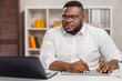© Acronym - Freelance designer workplace at home office. Young African-American man works using a computer, graphics tablet and other devices. Remote job.