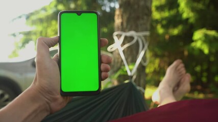 Close up hands guy using smartphone watching green screen on mobile phone