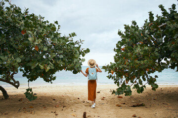 Canvas Print - woman tourist with backpack resting near the sea on the summer island