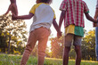 © liderina - African American family standing in nature and holding hands.