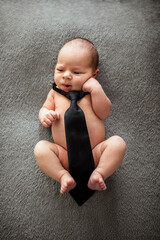 Wall Mural - Funny naked newborn baby with a tie