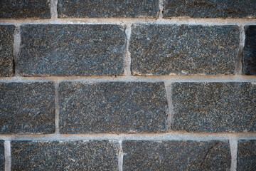 Poster - Wall of stones. Brick wall. Gray background with black geometric patterns. Black wall of rectangular stones, bricks. Part of a stone wall pattern for background, texture or text. close-up