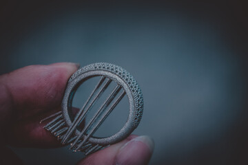 Man is holding object printed on metal 3d printer.