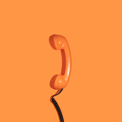 Wall Mural - Creative layout with old phone handset on bright orange background. Retro fashion style. Minimal aesthetic telephone call concept. Spring or summer idea. Flat lay.