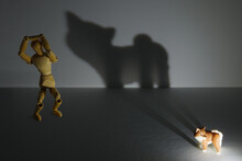 子犬が写し出す巨大な猛獣の影に怯えるデッサン人形
