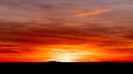 Luminous sunset in bright orange and red with black silhouette coastline.Shot in Sweden, Scandinavia