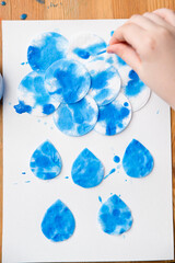  Let's make the rain. Boy coloring drop shape cotton pads. 5 minute crafts for children activities. Creative solutions at home.