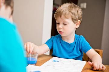 Let's make the rain. Boy coloring drop shape cotton pads. 5 minute crafts for children activities. Creative solutions at home.