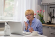 © Tetiana - Senior Smiling Woman has video chat  with grandchildren and shows  gestures  .  Online  School teacher  conducts  classes with children  E- learning concept .