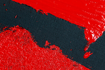 abstract creative background: red spots, strokes and splashes of colored primer when toning a black canvas, a temporary object.