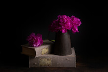 Hot Pink Peonies In An Old Vase On An Old Book 