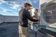 © spatesphoto - HVAC technician removing service panel