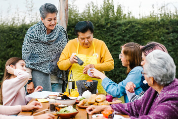 latin grandmother and granddaughter, daughter cooking mexican food at home, three generations of women in Mexico