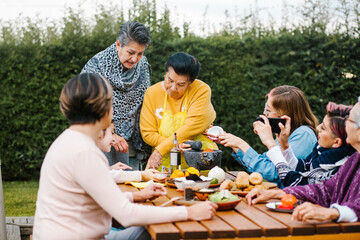 Wall Mural - latin grandmother and granddaughter, daughter cooking mexican food at home, three generations of women in Mexico