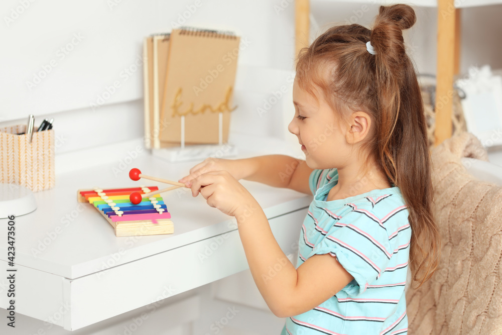 Cute little girl with xylophone at home