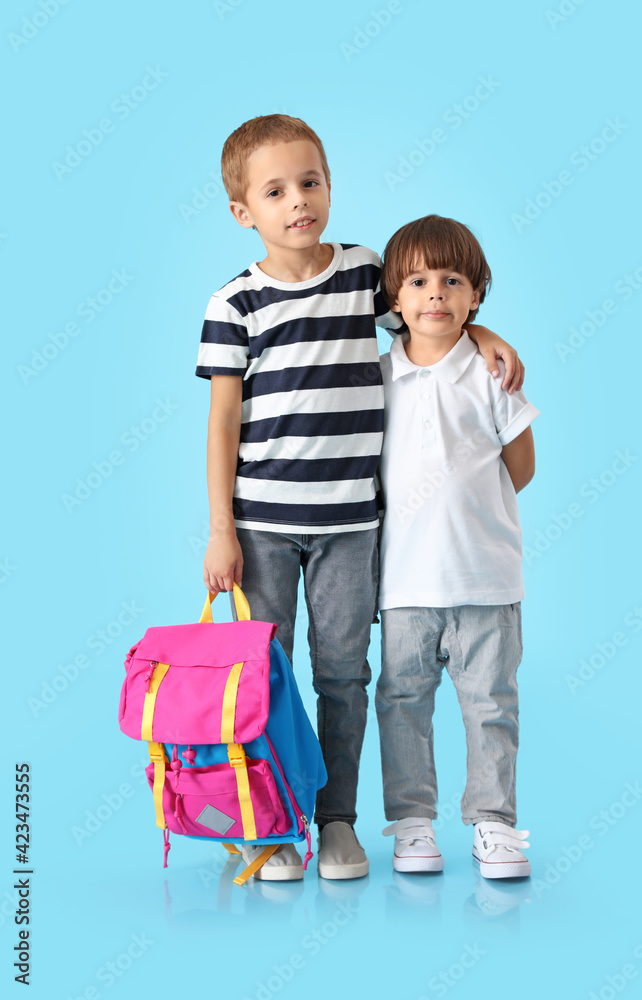 Cute little schoolboys on color background